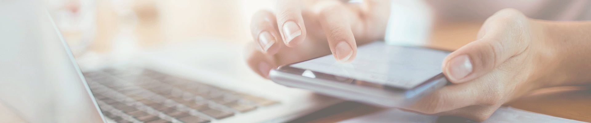 Person on her cellphone in front of a computer