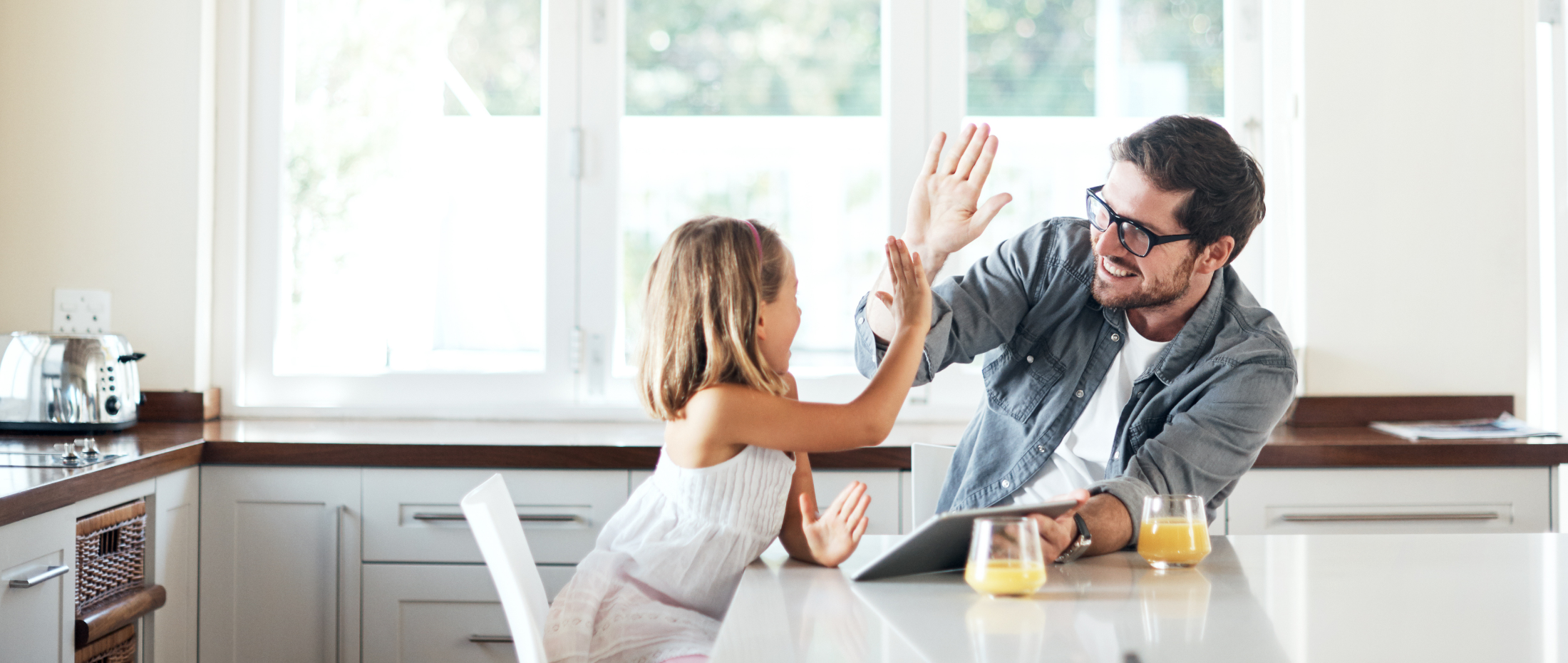 Père et fille dans une cuisine qui se tapent dans la main