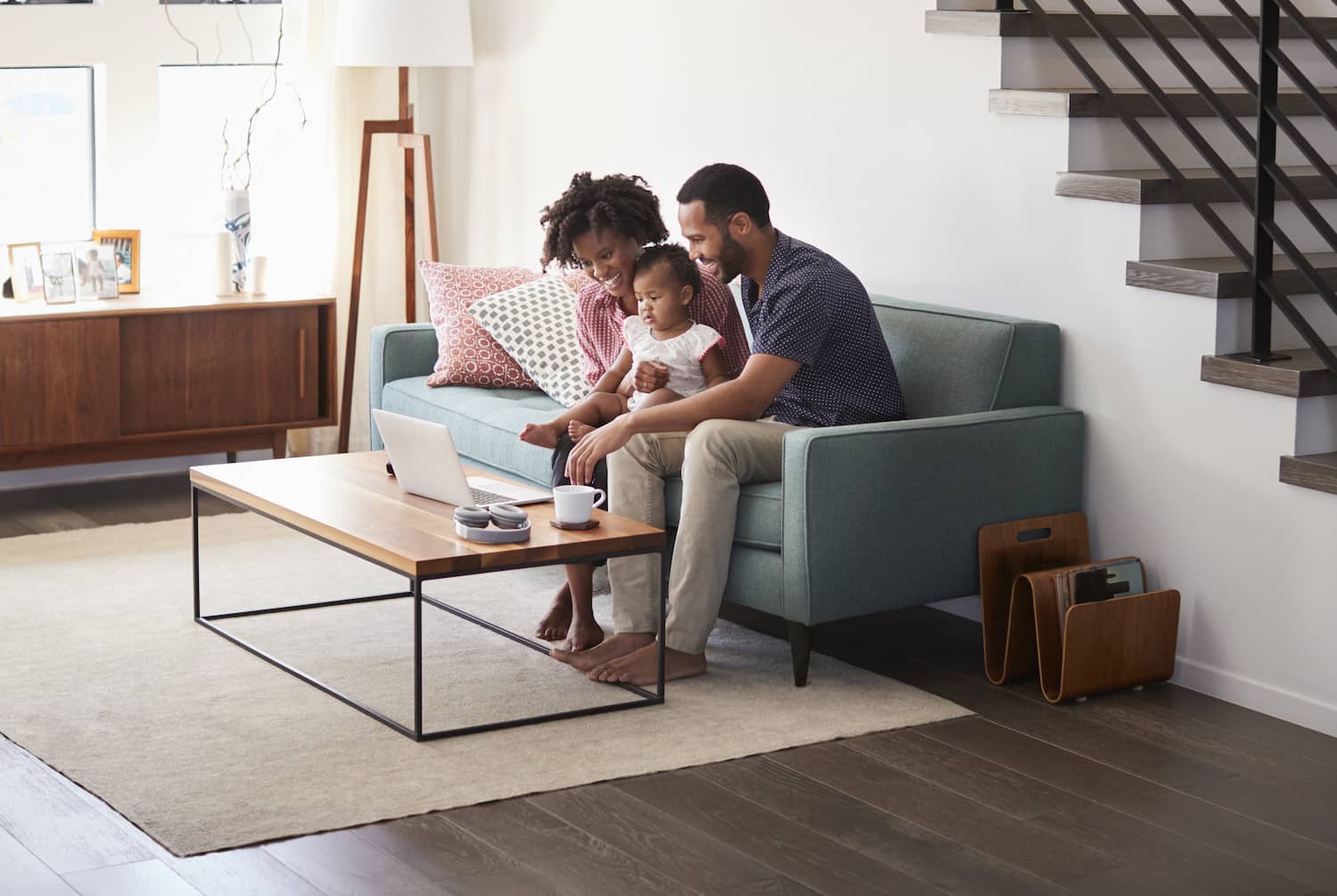 Famille assise dans le salon et regardant un ordinateur portable