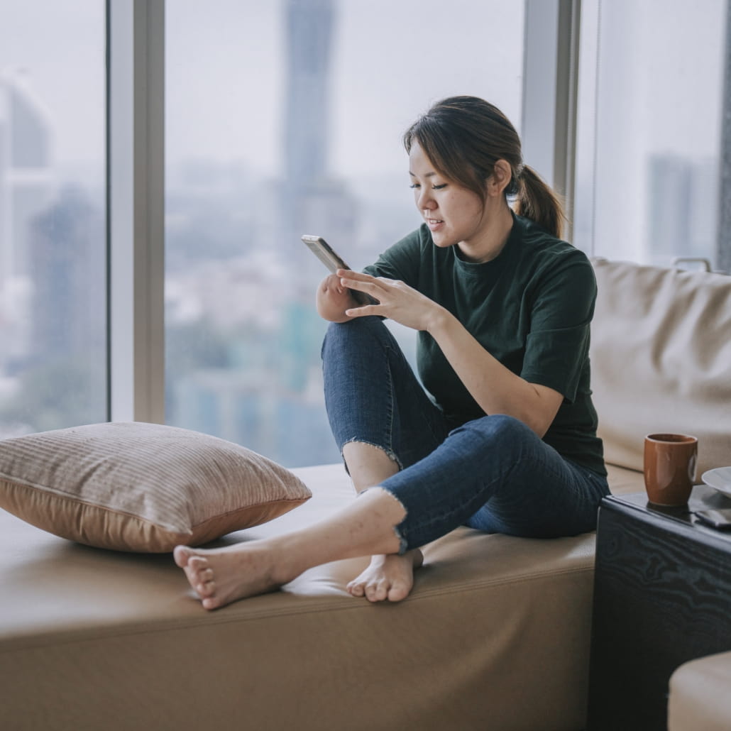 Woman using her cell phone in a living room