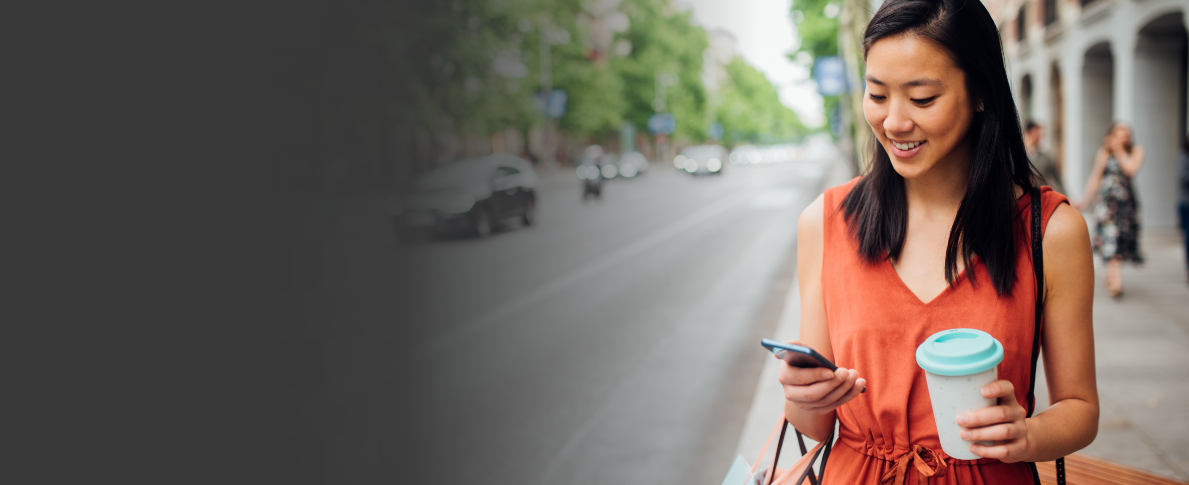 Femme marchant dans la rue et regardant son téléphone