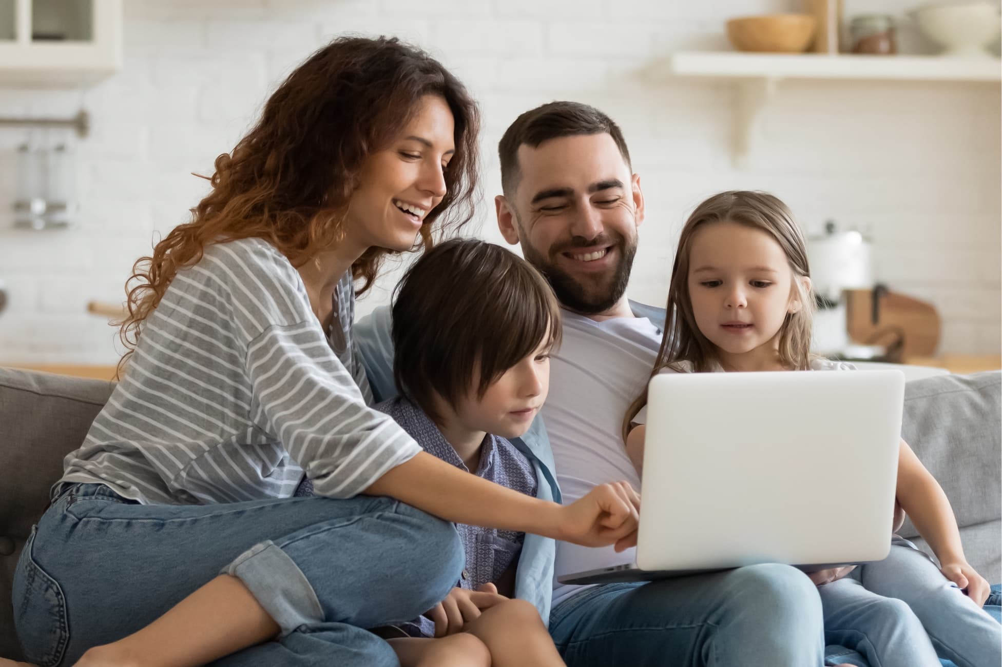 Family in a living room looking at a computer